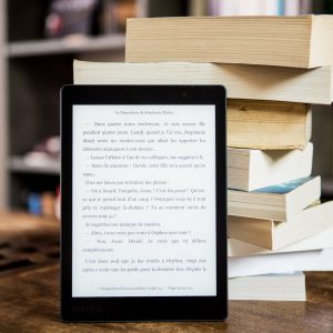 black tablet computer behind books